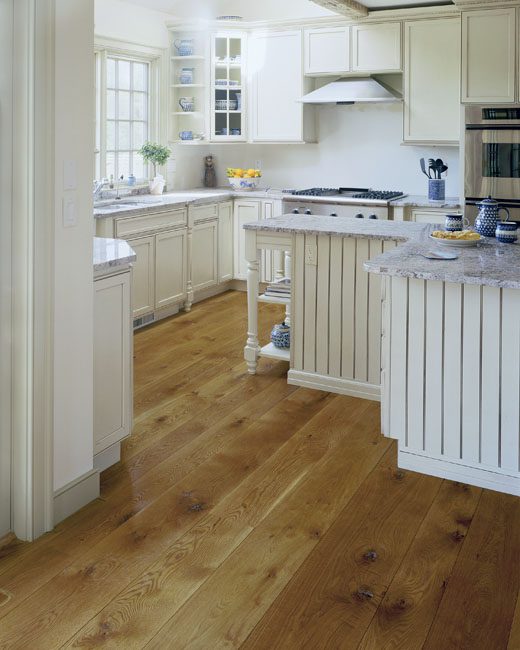 White Kitchen with brown wood floors White Kitchen with brown wood floors
